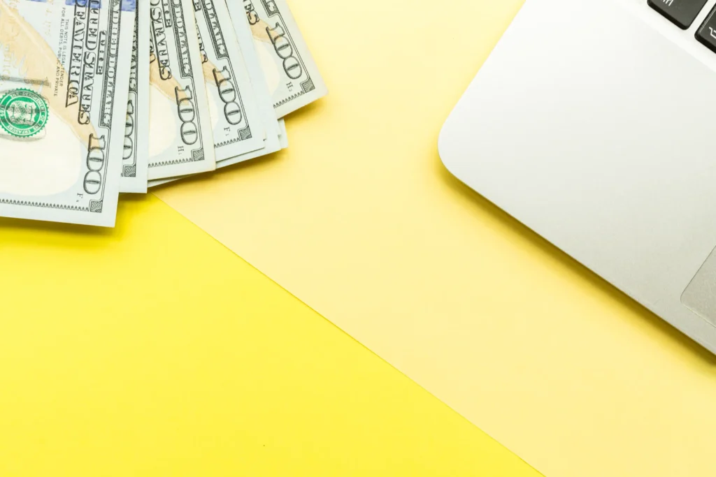 Dolares al lado de una laptop