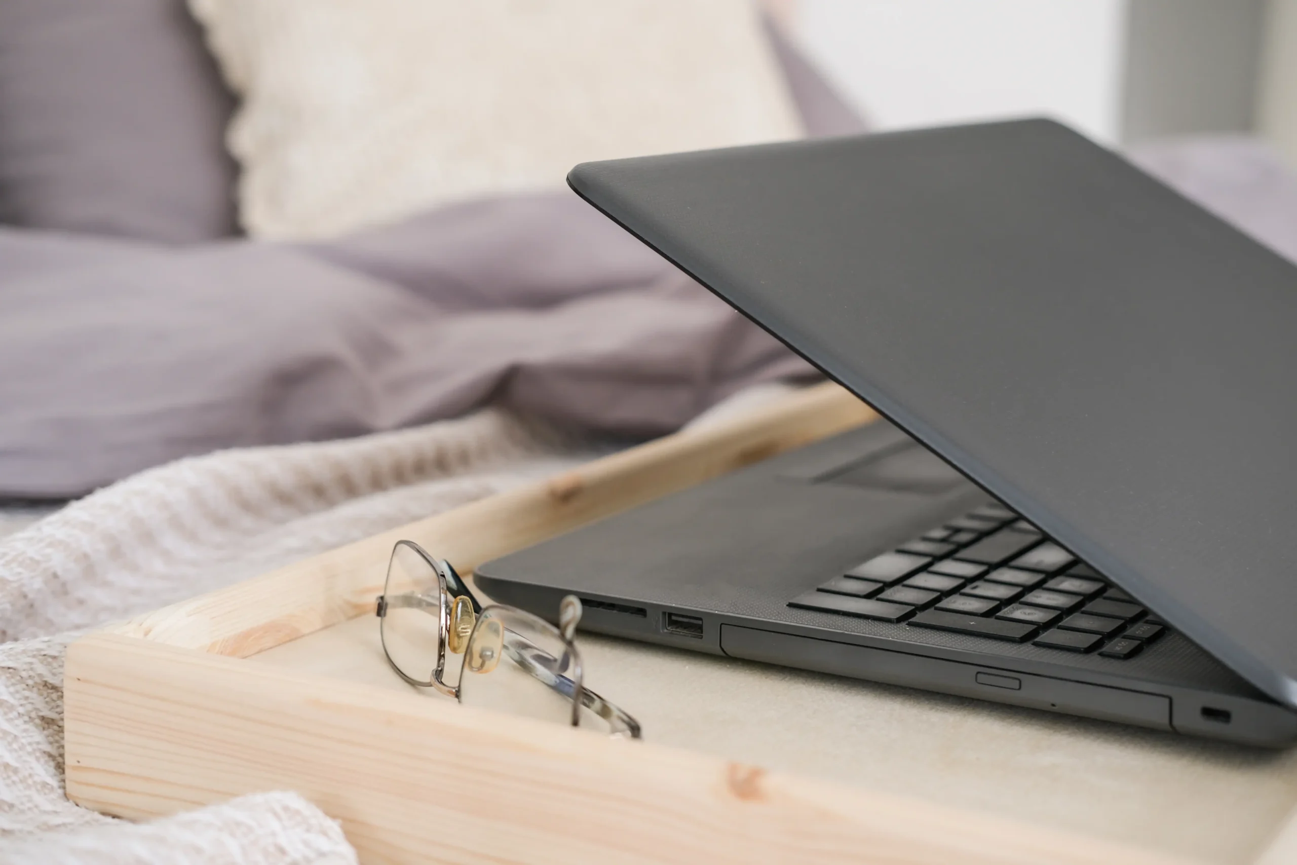 Ordenador portátil semi cerrado sobre una cama