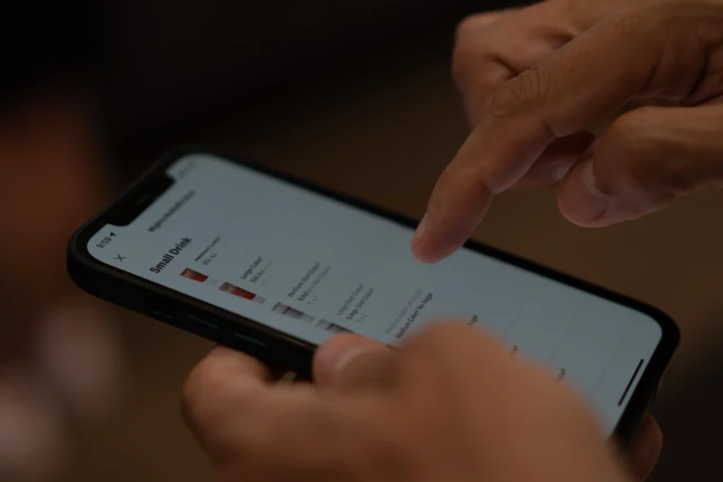 Mano usando un smartphone para revisar mensajes y aplicaciones, representando el trabajo digital de un chatter.