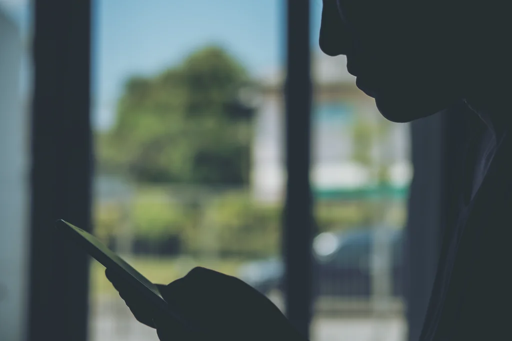 Persona anónima leyendo en el móvil un mensaje sospechoso de una falsa oferta de empleo de chatter